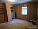Bedroom with wood paneling, carpeted floors, closet and a window, in need of renovations at 8860 Castor Rd, Salisbury, NC 28146