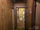 Hallway with light wood paneling, door, and patterned floors, needs updating at 8860 Castor Rd, Salisbury, NC 28146