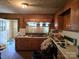 Kitchen with wood paneling, dated appliances, and countertops with items cluttered on them at 8860 Castor Rd, Salisbury, NC 28146