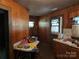 Kitchen with wood paneling and laminate counters, filled with clutter and cleaning supplies at 8860 Castor Rd, Salisbury, NC 28146