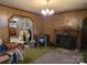 Retro living room with wood paneling, fireplace, chandelier, and vintage stove at 8860 Castor Rd, Salisbury, NC 28146