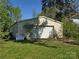 Large white metal outbuilding with rolling door and flat lawn on a sunny day at 8860 Castor Rd, Salisbury, NC 28146