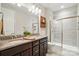 Bright bathroom features a double vanity with granite countertops and a glass shower at 9565 Horsebit Ln, Concord, NC 28027