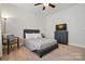 Well-lit bedroom featuring a bed and dresser against a light wall at 9565 Horsebit Ln, Concord, NC 28027