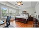 Bedroom with a ceiling fan, tray ceiling, hardwood floors, and lots of natural light at 9565 Horsebit Ln, Concord, NC 28027