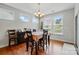 Sunlit dining room with hardwood floors, chandelier, and multiple windows at 9565 Horsebit Ln, Concord, NC 28027