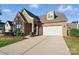 Beautifully landscaped home featuring a brick and stone facade, a two-car garage, and well-maintained lawn at 9565 Horsebit Ln, Concord, NC 28027