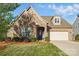 Charming brick and stone home with well-manicured lawn and a welcoming entrance, including an attached two-car garage at 9565 Horsebit Ln, Concord, NC 28027