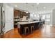 Stylish kitchen featuring a large island with seating, stainless steel appliances, and dark cabinetry at 9565 Horsebit Ln, Concord, NC 28027