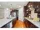 Modern kitchen with stainless steel appliances, granite countertops, gas cooktop, and dark wood cabinets at 9565 Horsebit Ln, Concord, NC 28027