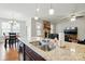Bright, open kitchen features stainless sink, granite countertops, and island with seating at 9565 Horsebit Ln, Concord, NC 28027