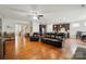 Expansive living room with hardwood floors, a black leather couch, and a clear view into the kitchen and dining areas at 9565 Horsebit Ln, Concord, NC 28027