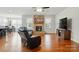 Spacious living room with hardwood floors, stone fireplace, and ample natural light from the windows at 9565 Horsebit Ln, Concord, NC 28027