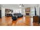 Open-concept living area with hardwood floors, stone fireplace, and seamless flow to the kitchen and dining spaces at 9565 Horsebit Ln, Concord, NC 28027