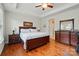 Bedroom with a ceiling fan, tray ceiling, hardwood floors, and bedside dressers at 9565 Horsebit Ln, Concord, NC 28027