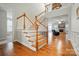 Elegant staircase with wood steps and white banister leading to an open living area at 9565 Horsebit Ln, Concord, NC 28027