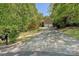 Long driveway leading to a brick house with a two-car garage, framed by lush green trees at 9600 Lockhorn Ct, Mint Hill, NC 28227