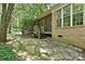 Stone patio with adjacent porch, nestled among mature trees for shade and privacy, providing outdoor living space at 9600 Lockhorn Ct, Mint Hill, NC 28227