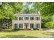 Charming yellow two-story home with blue shutters, lush front lawn, and mature shade trees at 1007 Doby Springs Dr, Charlotte, NC 28262