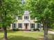 Charming yellow two-story home with blue shutters, lush front lawn, and mature shade trees at 1007 Doby Springs Dr, Charlotte, NC 28262