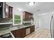 Bright kitchen featuring dark cabinets, stainless steel appliances, and views of the backyard at 1007 Doby Springs Dr, Charlotte, NC 28262