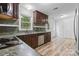 Well-lit kitchen featuring dark cabinets, stainless steel appliances, and views of the backyard at 1007 Doby Springs Dr, Charlotte, NC 28262