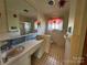 Retro bathroom featuring tile flooring, built-in vanity, and large mirror above the sinks at 1012 Burrage Ne Rd, Concord, NC 28025