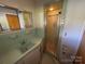 Bathroom with a green tiled vanity, sink, and a shower with a glass door at 1012 Burrage Ne Rd, Concord, NC 28025