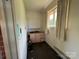 Small laundry room with old pink cabinets, a window, and dirty carpet at 1012 Burrage Ne Rd, Concord, NC 28025