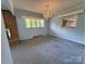 Bright living room with neutral walls, large windows, and a classic chandelier at 1012 Burrage Ne Rd, Concord, NC 28025