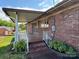 Covered brick porch with white railings and a view of the surrounding greenery, perfect for relaxing at 1012 Burrage Ne Rd, Concord, NC 28025