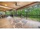 Inviting screened porch with wooded view, tile floor and wood plank ceiling with ceiling fan at 1068 Grant Dr, Denver, NC 28037