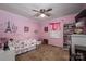 Bright bedroom with light pink walls, a ceiling fan and decorative wall art above the bed at 111 Peoria Ln, Kings Mountain, NC 28086