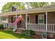 Inviting front porch with brick facade, white railing, and a welcoming American flag at 111 Peoria Ln, Kings Mountain, NC 28086