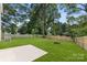 A spacious, green backyard is surrounded by a wooden fence and mature trees, perfect for relaxation at 1141 Thayer Glen Ct, Charlotte, NC 28213