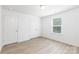 This bedroom features wood-look flooring, a window with blinds, and two doors at 1141 Thayer Glen Ct, Charlotte, NC 28213