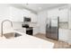 Modern kitchen with white cabinets, stainless steel appliances, marble backsplash, and quartz countertops at 1141 Thayer Glen Ct, Charlotte, NC 28213