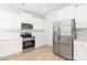 Modern kitchen featuring white cabinets, stainless steel appliances, marble backsplash, and hardwood floors at 1141 Thayer Glen Ct, Charlotte, NC 28213