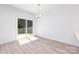 Bright living area featuring light wood-look flooring, with a sliding glass door to a backyard at 1141 Thayer Glen Ct, Charlotte, NC 28213