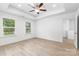 Bright main bedroom with tray ceilings, wood-look flooring, and large windows at 1141 Thayer Glen Ct, Charlotte, NC 28213