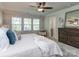 This bedroom features a ceiling fan, 3 large windows for natural light, and a tastefully decorated dresser at 12214 Ardrey Park Dr, Charlotte, NC 28277