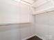 Walk-in closet with white wire shelving and dark wood flooring at 12214 Ardrey Park Dr, Charlotte, NC 28277