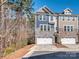 Charming townhome showcasing stone accents, a two-car garage, and a well-manicured lawn at 12214 Ardrey Park Dr, Charlotte, NC 28277