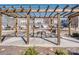 Community fire pit beneath a pergola surrounded by stone seating and attractive townhome-style condo buildings at 12214 Ardrey Park Dr, Charlotte, NC 28277