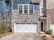 Two-car garage with gray stone and blue shingle exterior at 12214 Ardrey Park Dr, Charlotte, NC 28277