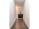 Long, well-lit hallway with hardwood floors, neutral walls, and a decorative cabinet with artwork at 12214 Ardrey Park Dr, Charlotte, NC 28277