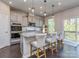 Bright kitchen boasts gray cabinets, granite countertops, stainless appliances, and a kitchen island with barstool seating at 12214 Ardrey Park Dr, Charlotte, NC 28277