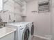 This laundry room includes a sink, shelving, a washer and a dryer at 12214 Ardrey Park Dr, Charlotte, NC 28277