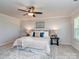Comfortable main bedroom featuring a ceiling fan, bedside tables, soft rug, decorative pillows, and plenty of natural light at 12214 Ardrey Park Dr, Charlotte, NC 28277