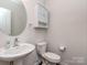 A clean and simple powder room with a pedestal sink and neutral decor at 12214 Ardrey Park Dr, Charlotte, NC 28277